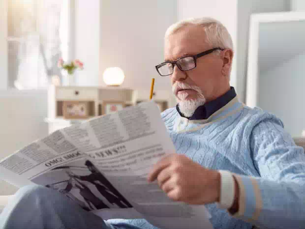 Starszy mężczyzna czytający gazetę